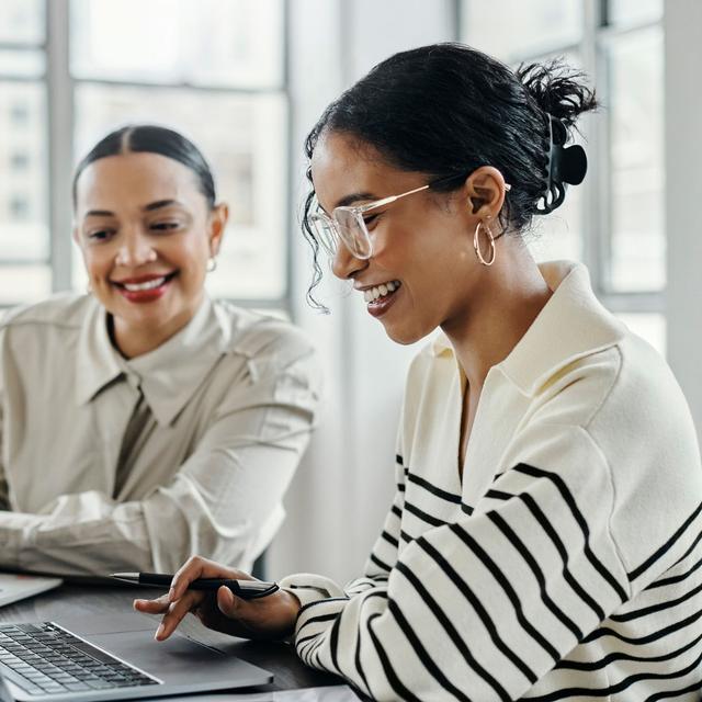 Happy female intern collaborating with a mentor to learn new skills during her internship